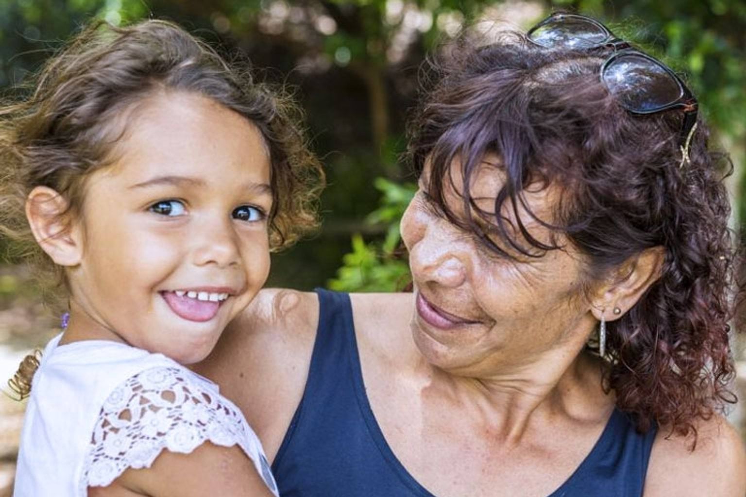 A woman hugging a smiling girl